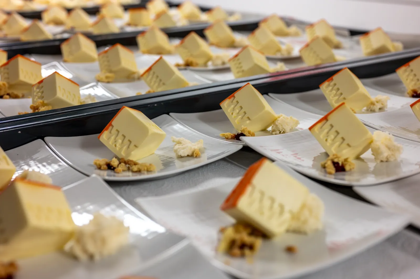 Dessert-Teller in langen Reihen, angerichtet für ein Gala-Dinner