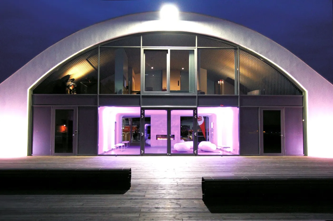 Der Hangar bei Nacht mit violett beleuchtetem Eingang