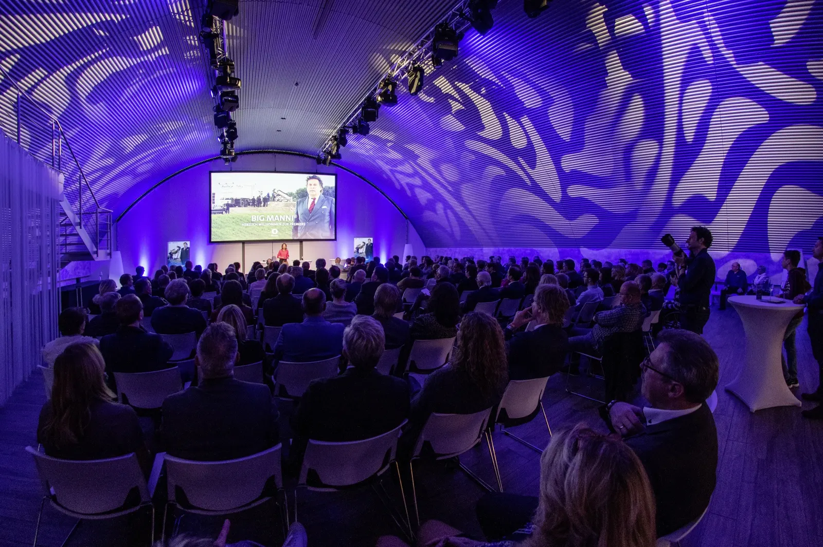Vortrag im voll besetzten Hangar vor der Videowall