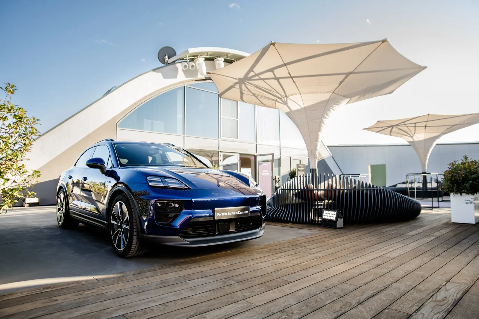 Porsche Macan auf der Terrasse vor dem Hangar unter Sonnensegeln
